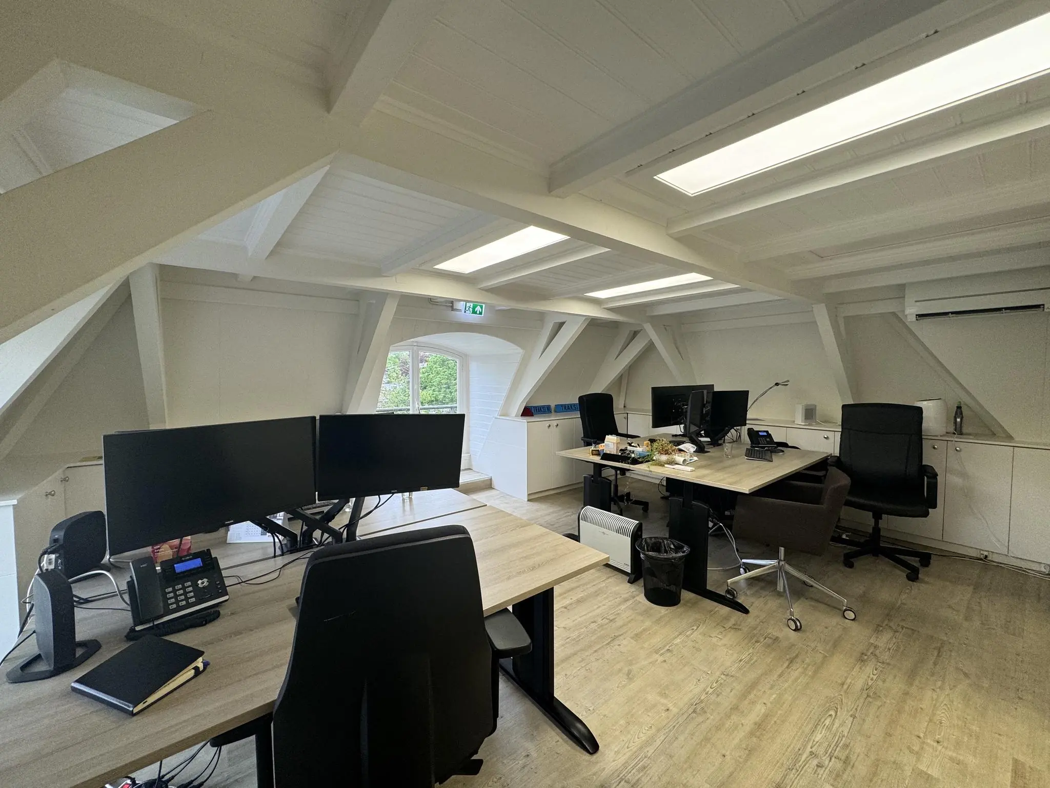 Modern kantoor met meerdere bureaus, computerschermen en stoelen in een lichte zolderruimte aan de Dorpsstraat voor Steenstraat.